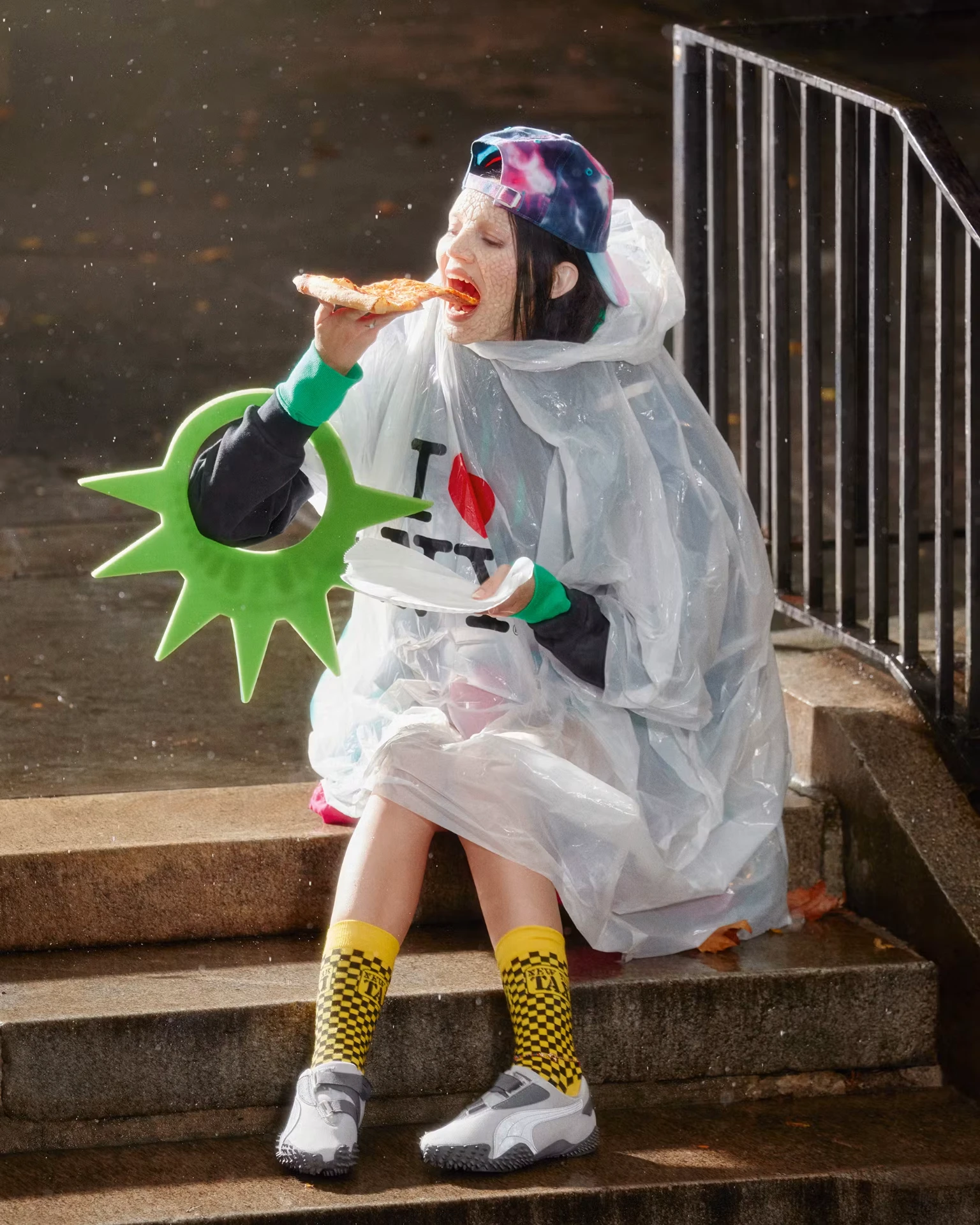 PUMA Mostro campaign: person in rain poncho eating pizza on Berlin steps in Mostro sneakers